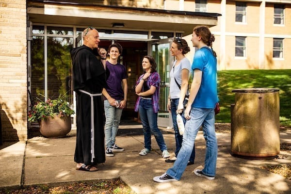 Father Dave with Students outside a dorm