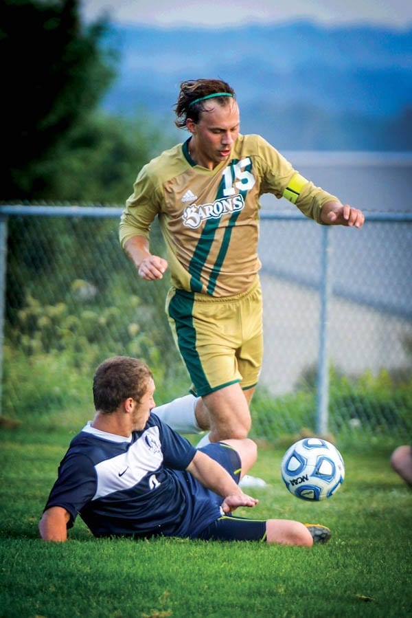 soccer player tackling opposing teammate