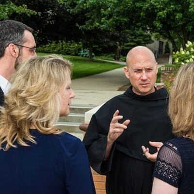 Father Dave speaking with a small group of people