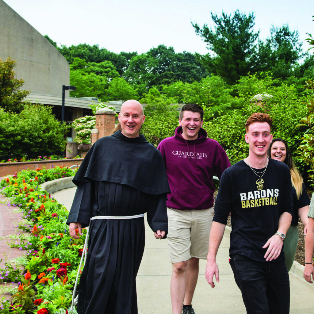 students walking with Father dave outside the Christ the King chapel